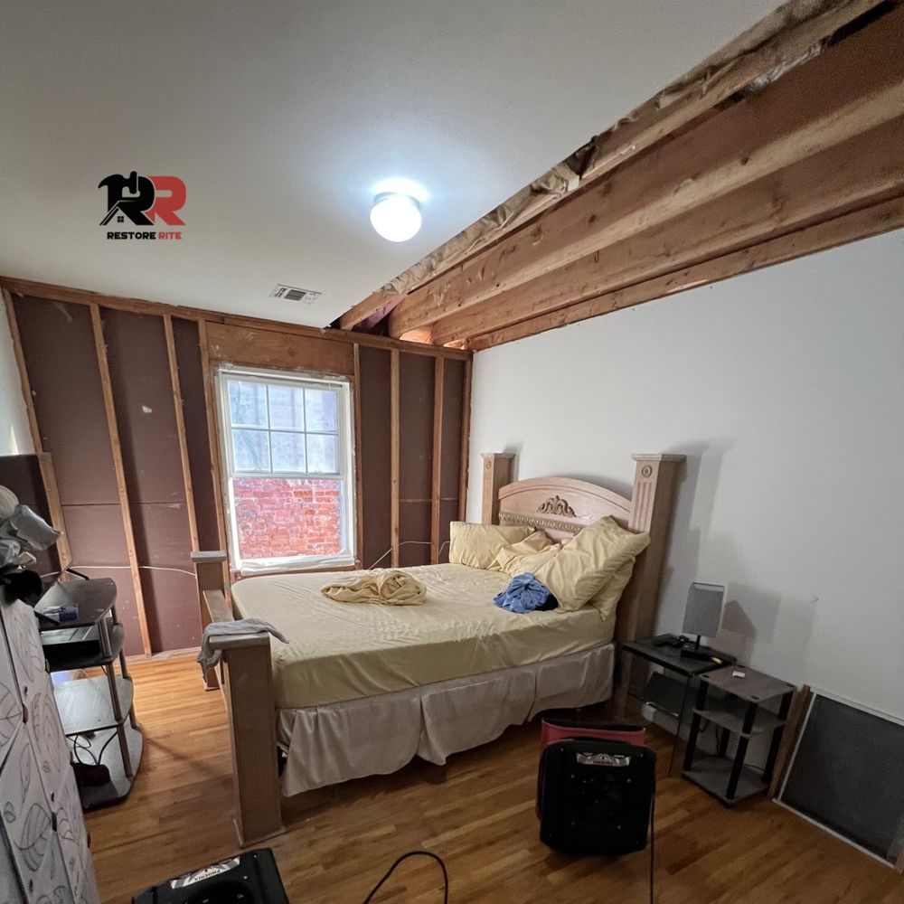Structural wall damage inside a storm-affected bedroom